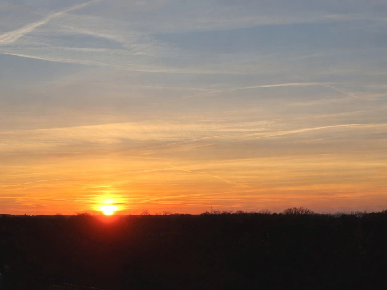 Sonnenuntergang am Horizont mit warmen Farben und ruhigem Himmel
