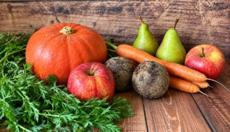K&uuml;rbis, &Auml;pfel, Birnen, M&ouml;hren und weiteres saisonales Herbstgem&uuml;se auf einem Holztisch