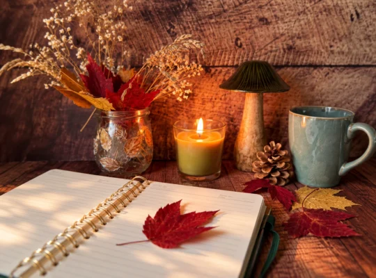 Alt-Text: Geöffnetes Journal mit Kerze, Tasse und Herbstblättern für Journaling im Herbst