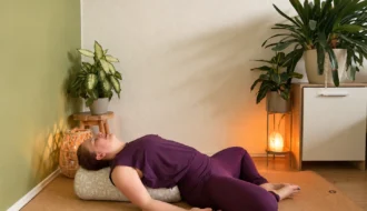 Yin Yoga &ndash; Frau im liegenden Schmetterling (Supta Baddha Konasana) auf einer Yogamatte.
